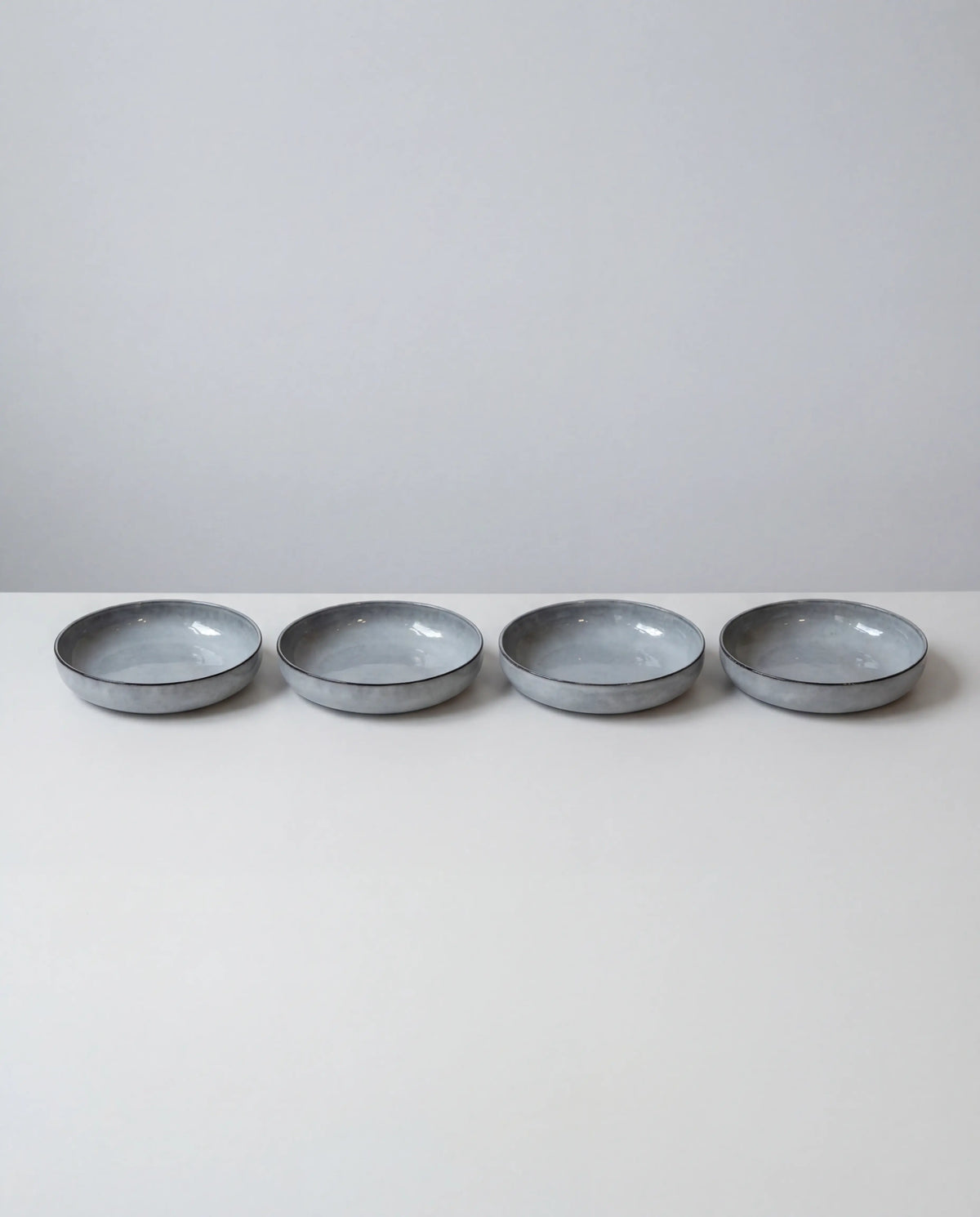 Row of shallow blue gray bowls from the Nordic Fjord dinnerware set