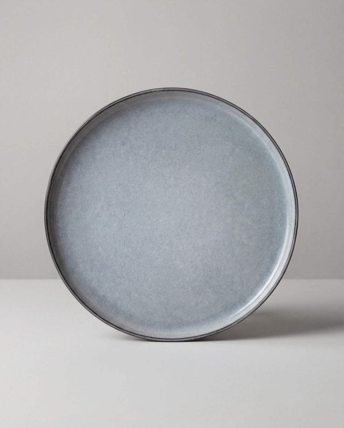 Close-up of a round Nordic Fjord small plate with grey glaze and a dark rim.