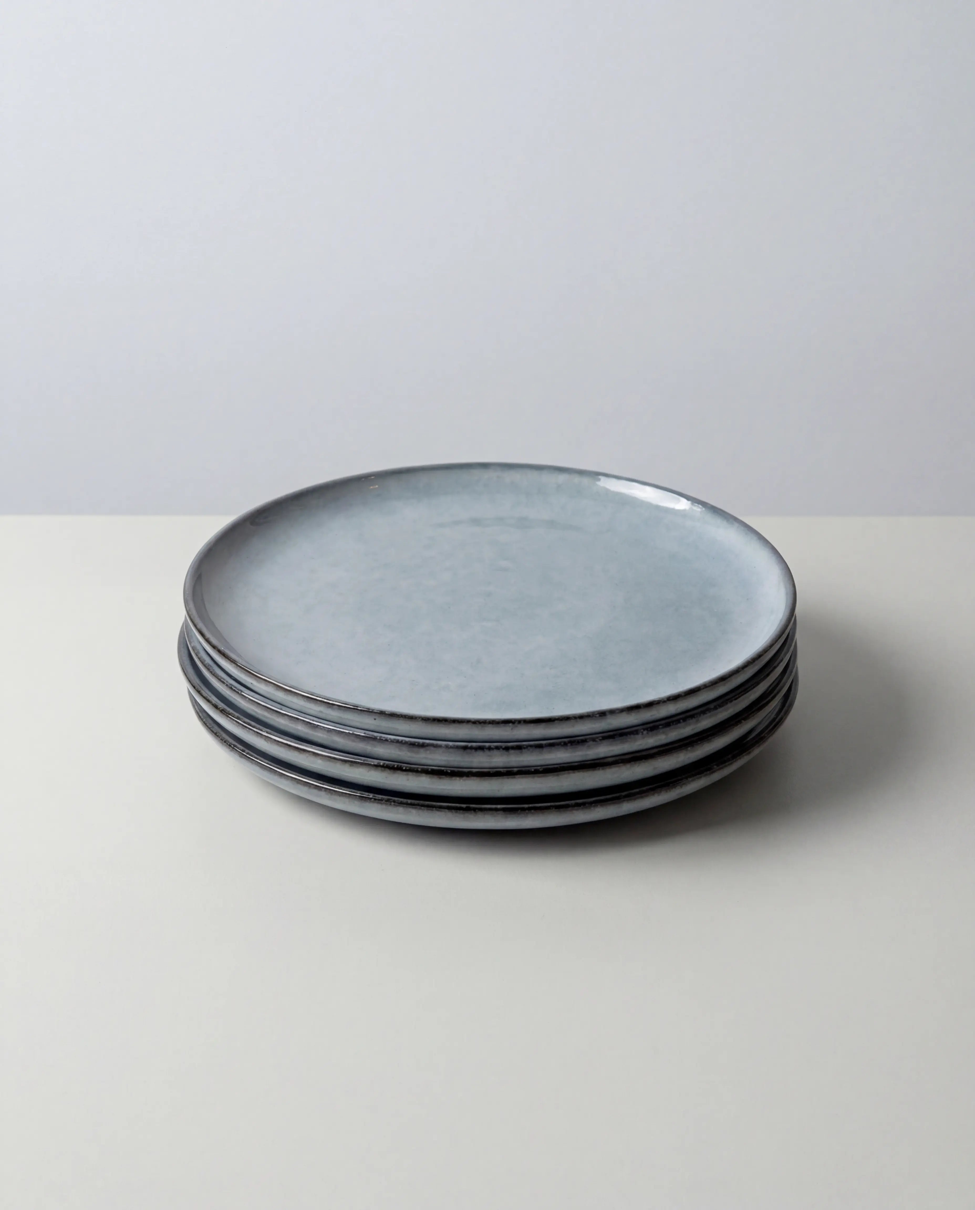 Set of six Nordic Fjord small plates in a bluish gray glaze stacked together