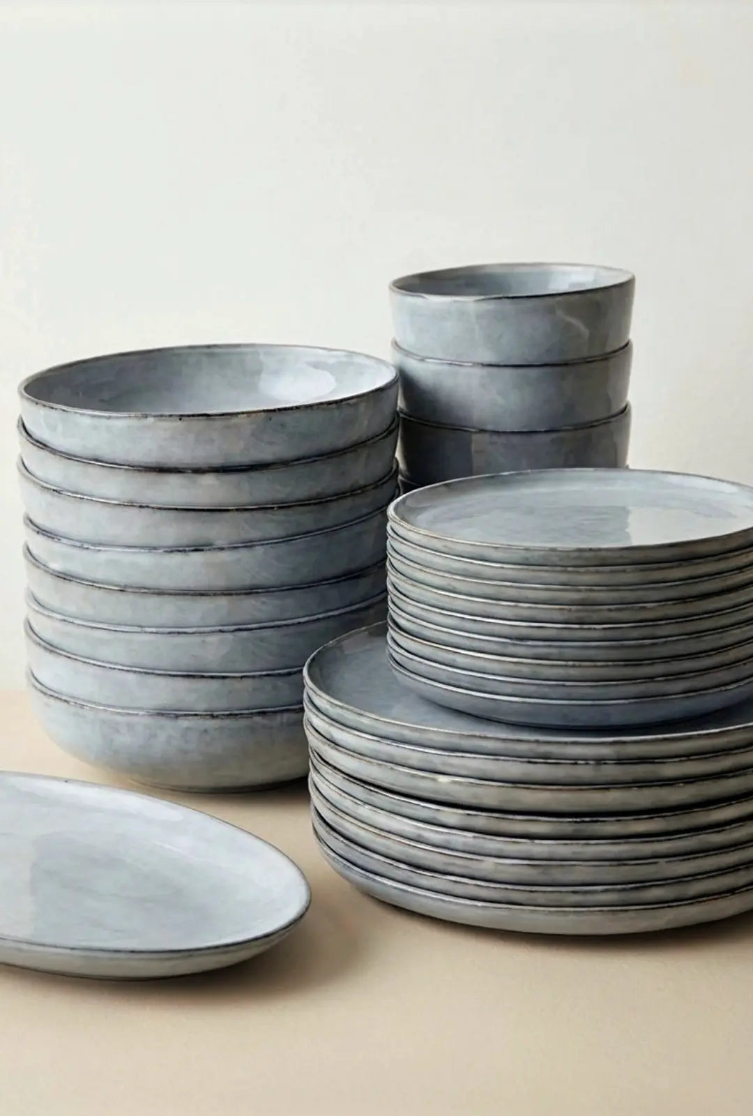 Stacks of blue gray bowls and plates from Scandic Soul Nordic Fjord dinnerware set