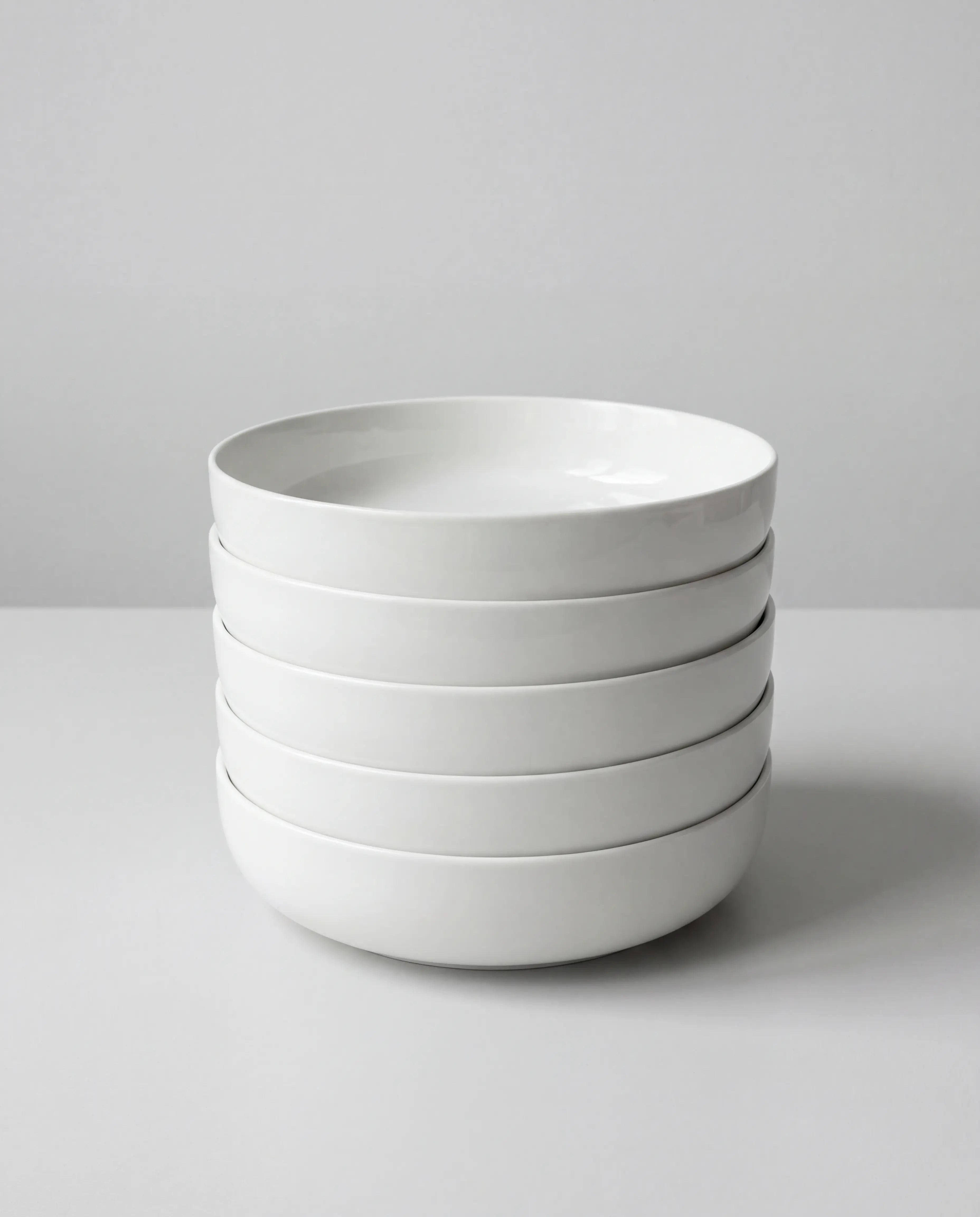 Stack of white ceramic bowls from the Vela Alba 40 piece dish set