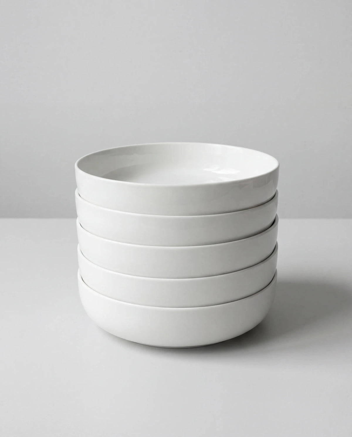 Stack of white ceramic bowls from the Vela Alba 40 piece dish set
