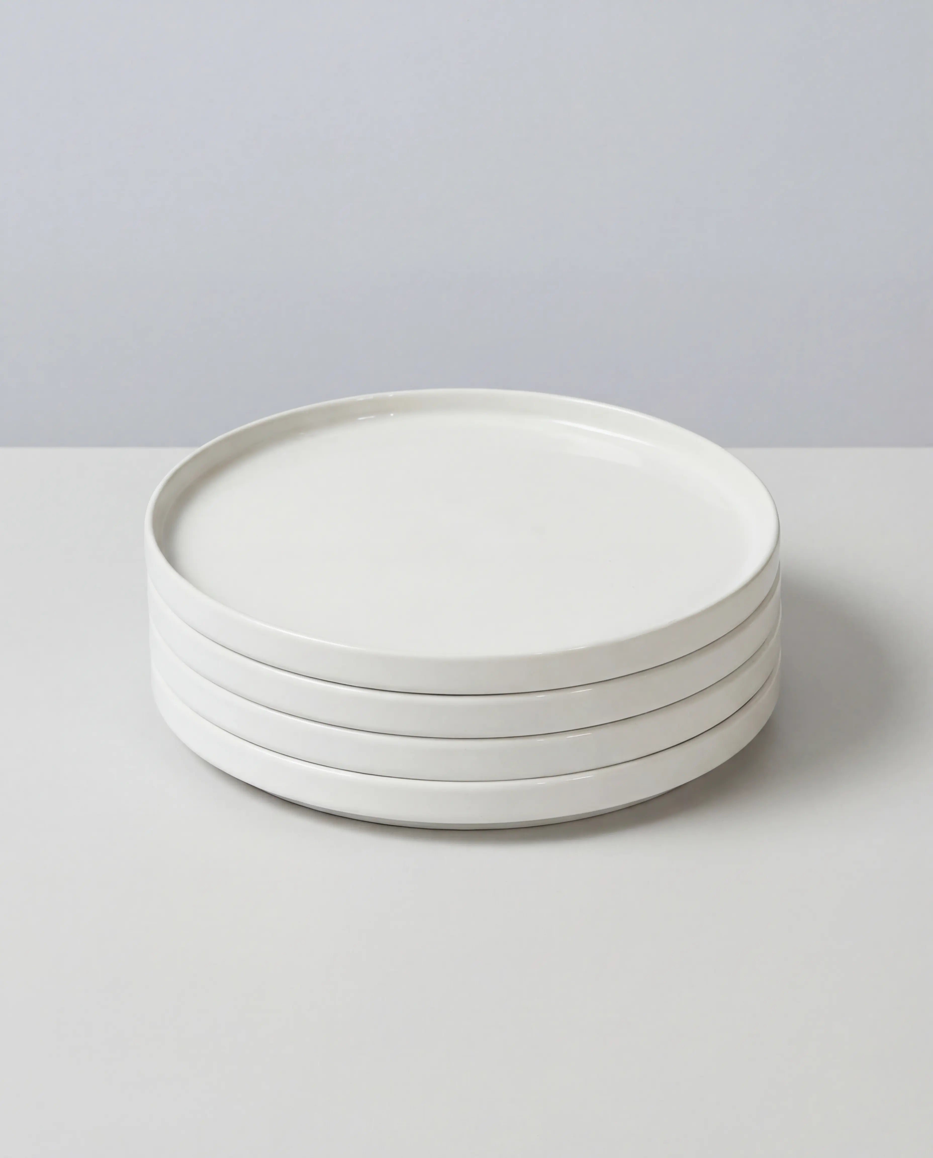 Stack of white porcelain small plates from the Vela Alba set
