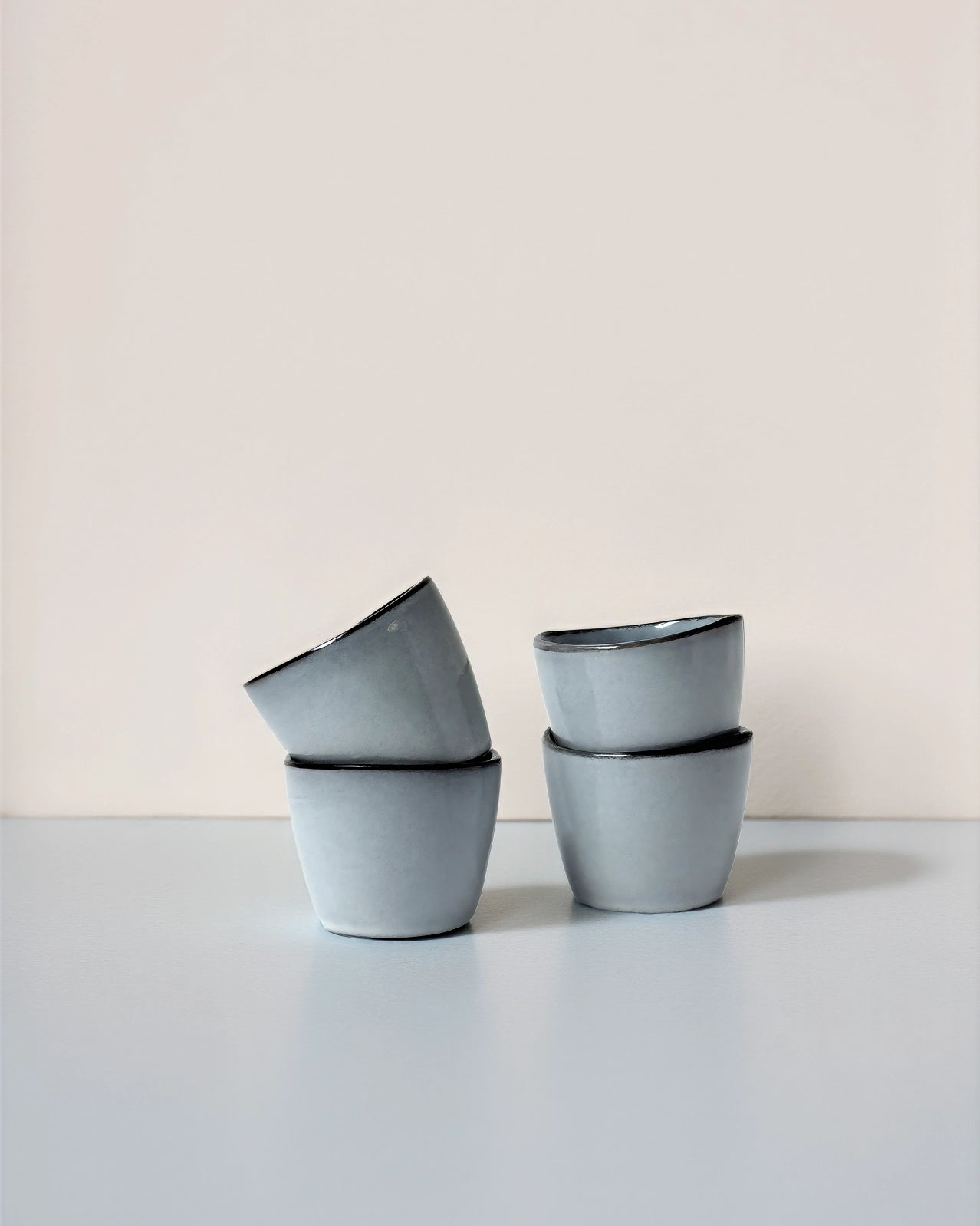 Set of four light blue Nordic Fjord Dip espresso cups stacked on a pale surface