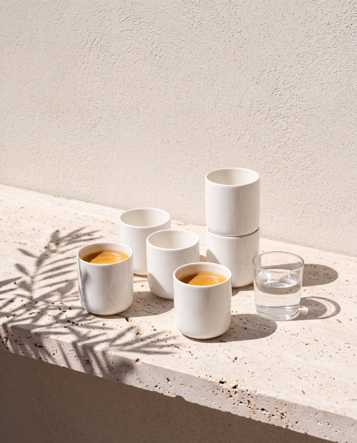 Sechs Vela Alba Espressobecher auf Travertin, zwei mit Espresso