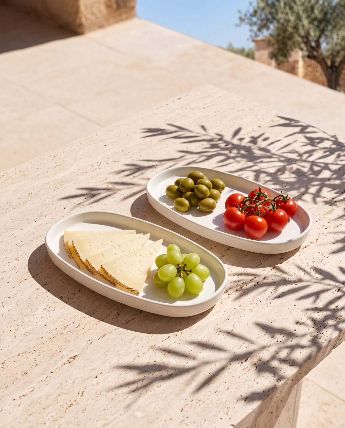 Zwei ovale Vela Alba Servierplatten mit Käse, Trauben, Oliven und Tomaten