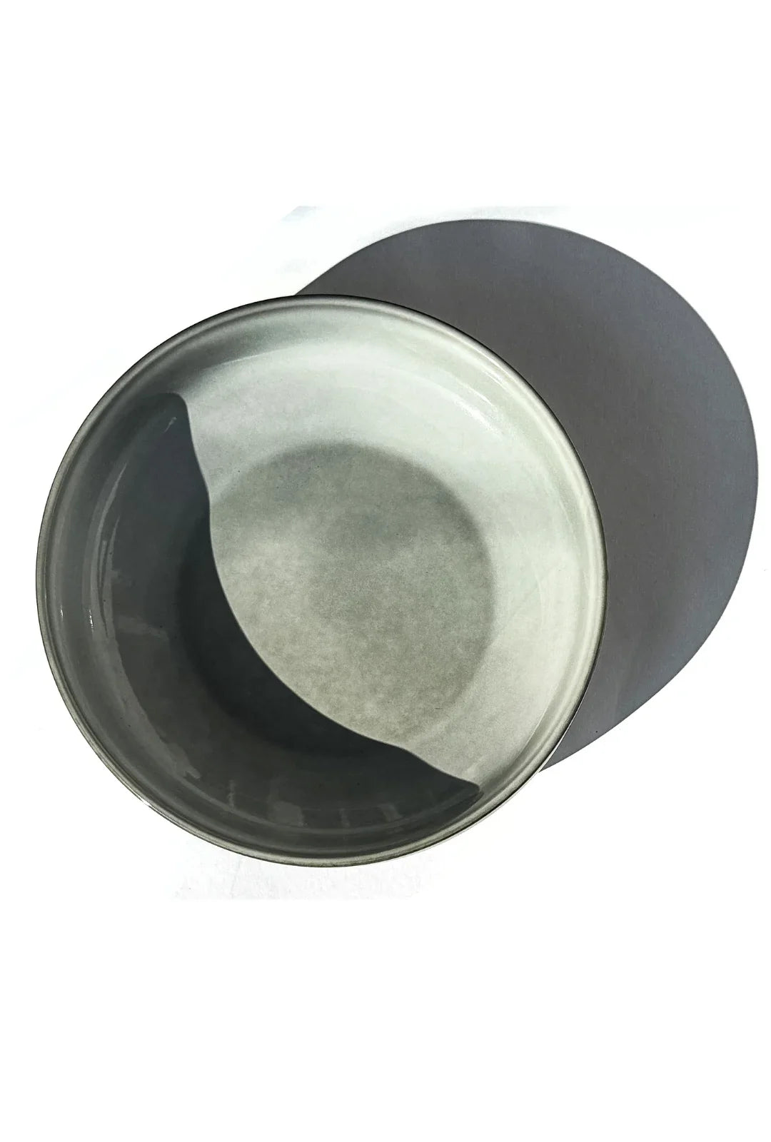 Top view of a grey ceramic bowl nestled in a dark grey round plate from the Nordic Forest dish set