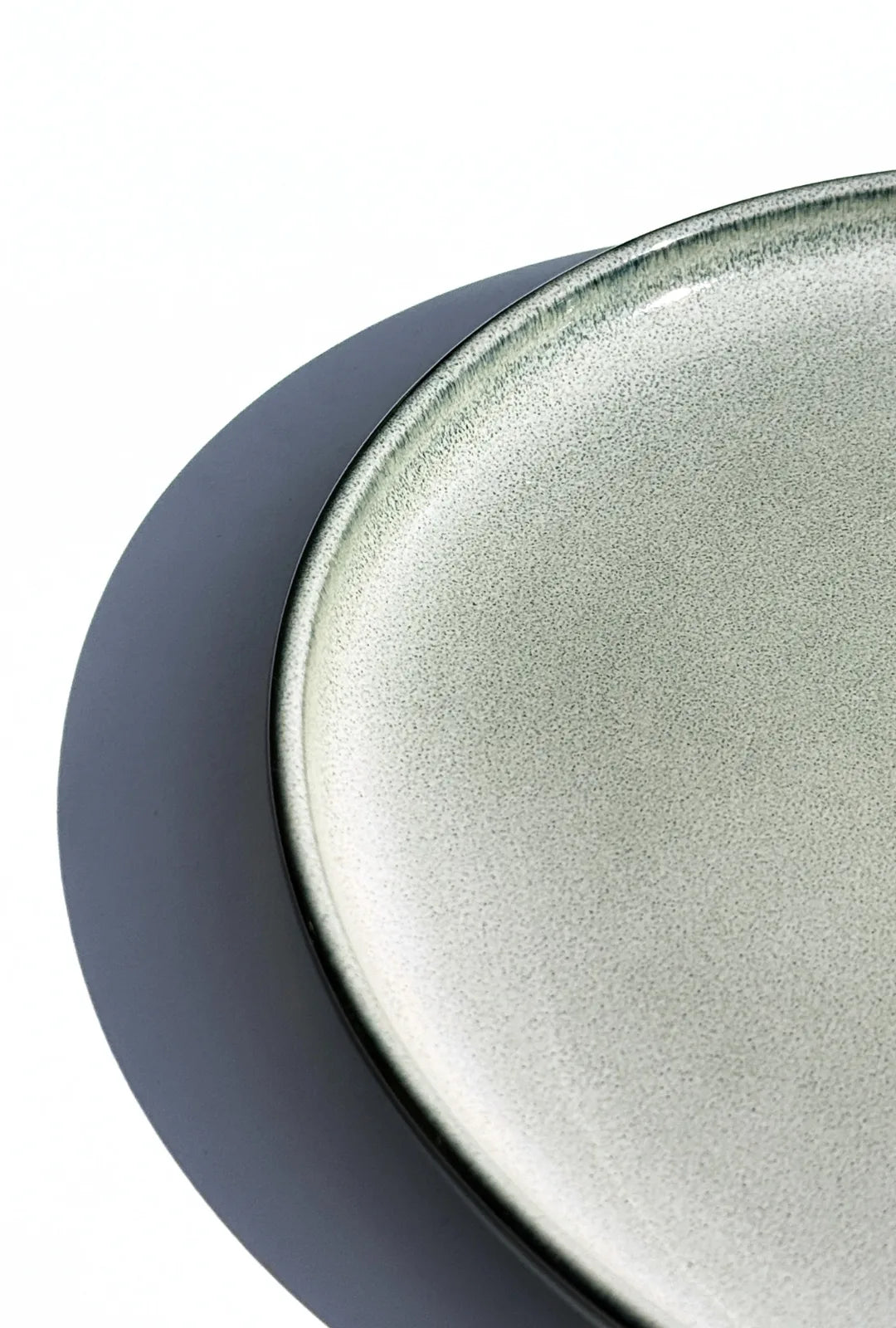 Close-up of Nordic Forest plate with a dark navy rim and speckled grey interior