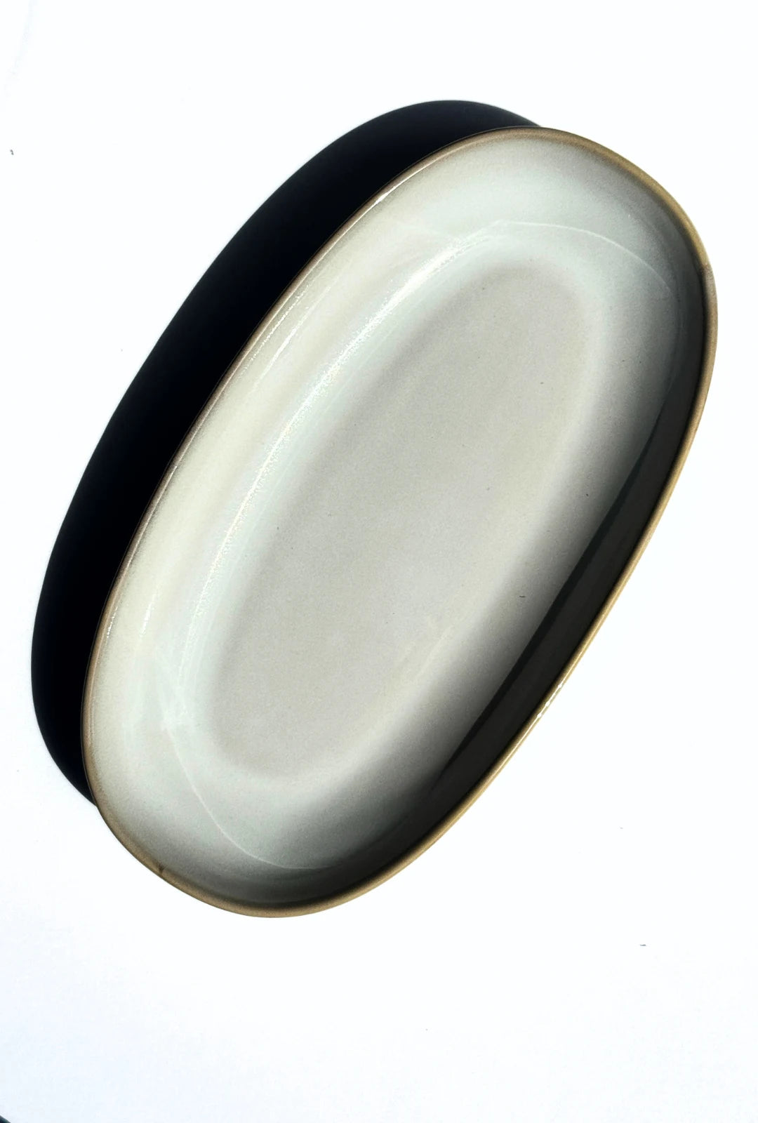 Oval serving plate with dark outer edge gold rim and pale interior