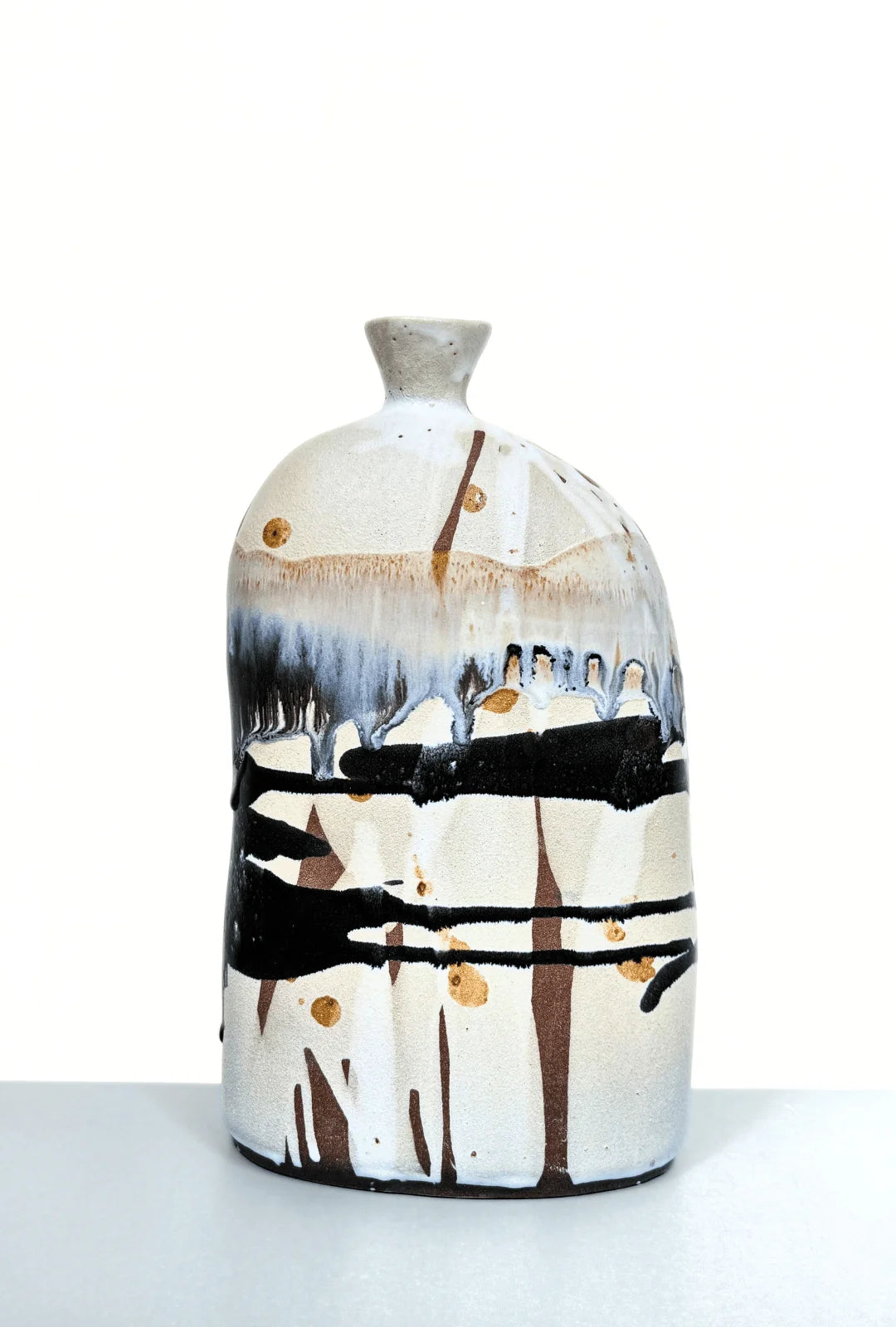 Boa Tarde Vase with abstract drips in beige blue and black on a tall rounded ceramic form.