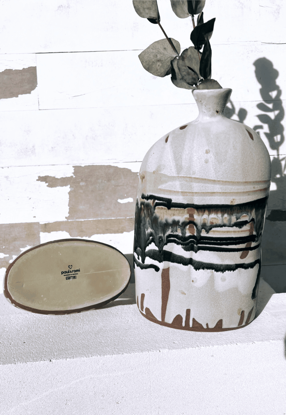 Boa Tarde Vase with dried eucalyptus stems against a white distressed wooden backdrop