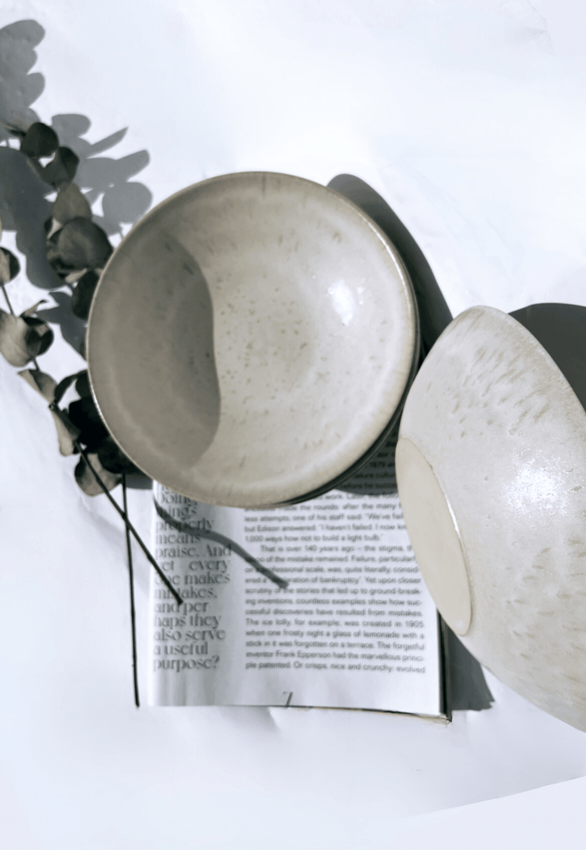 Beige ceramic pasta plates from Bom Dia four piece set stacked with eucalyptus sprigs.