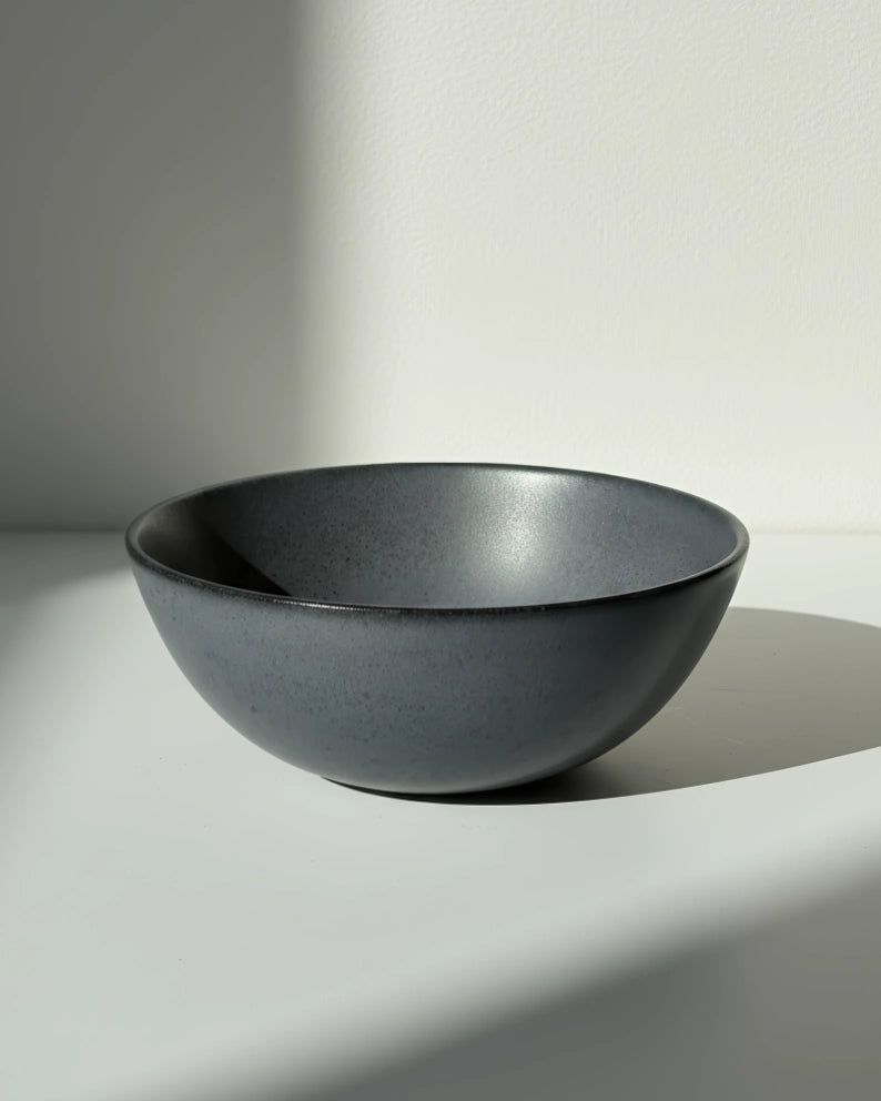 Boa Noite bowl in cool gray glaze on a white surface with soft lighting