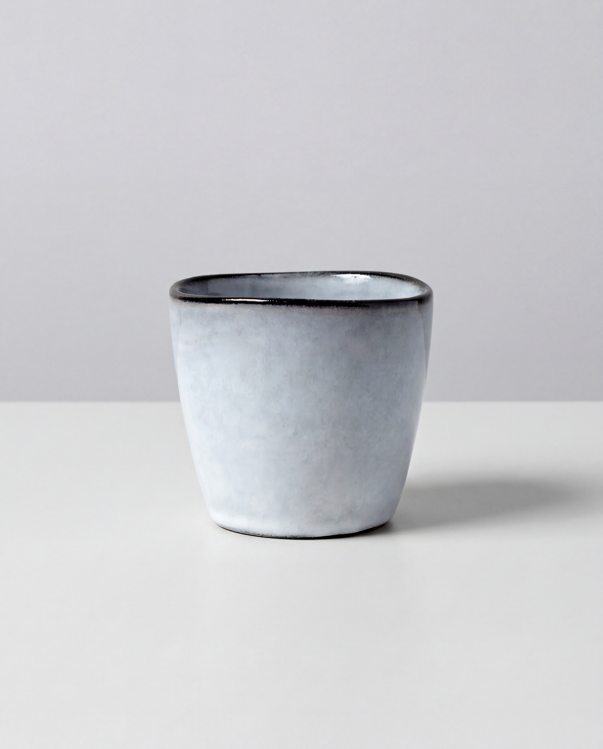 Close up of a Nordic Fjord dip espresso cup with pale blue gray glaze and dark rim