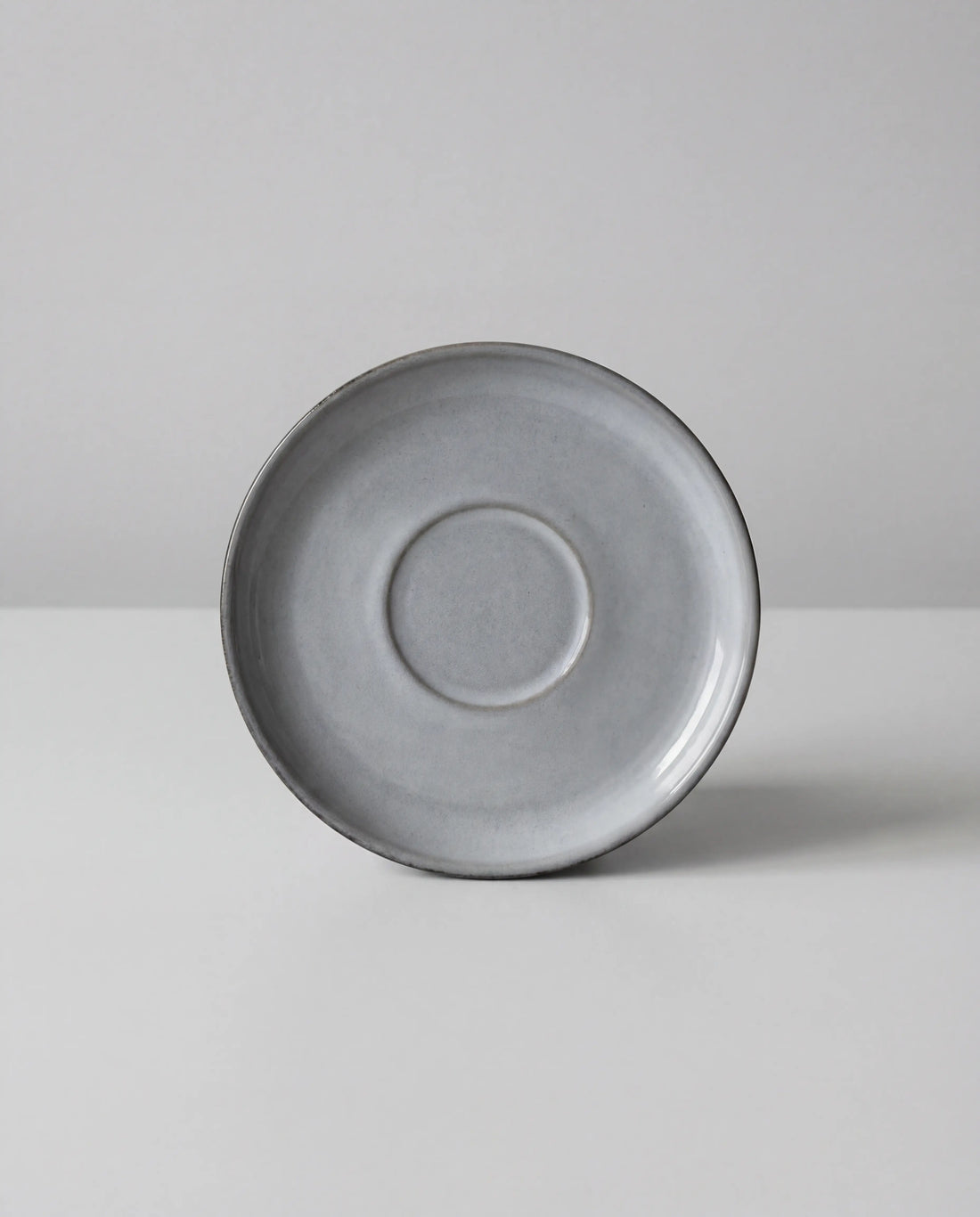 Scandic Soul Nordic Fjord saucer in grey photographed from above against a pale background.