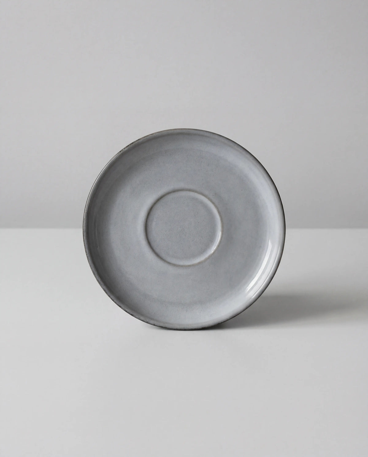 Scandic Soul Nordic Fjord saucer in grey photographed from above against a pale background.