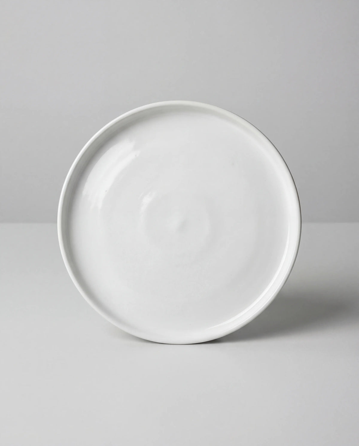Close up of a white porcelain small plate on a gray background