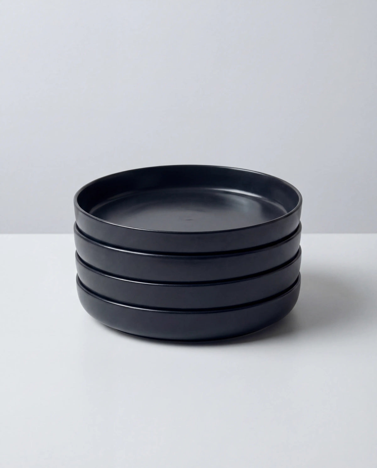 Stacked matte black pasta bowls from Vela Luna Pastateller set