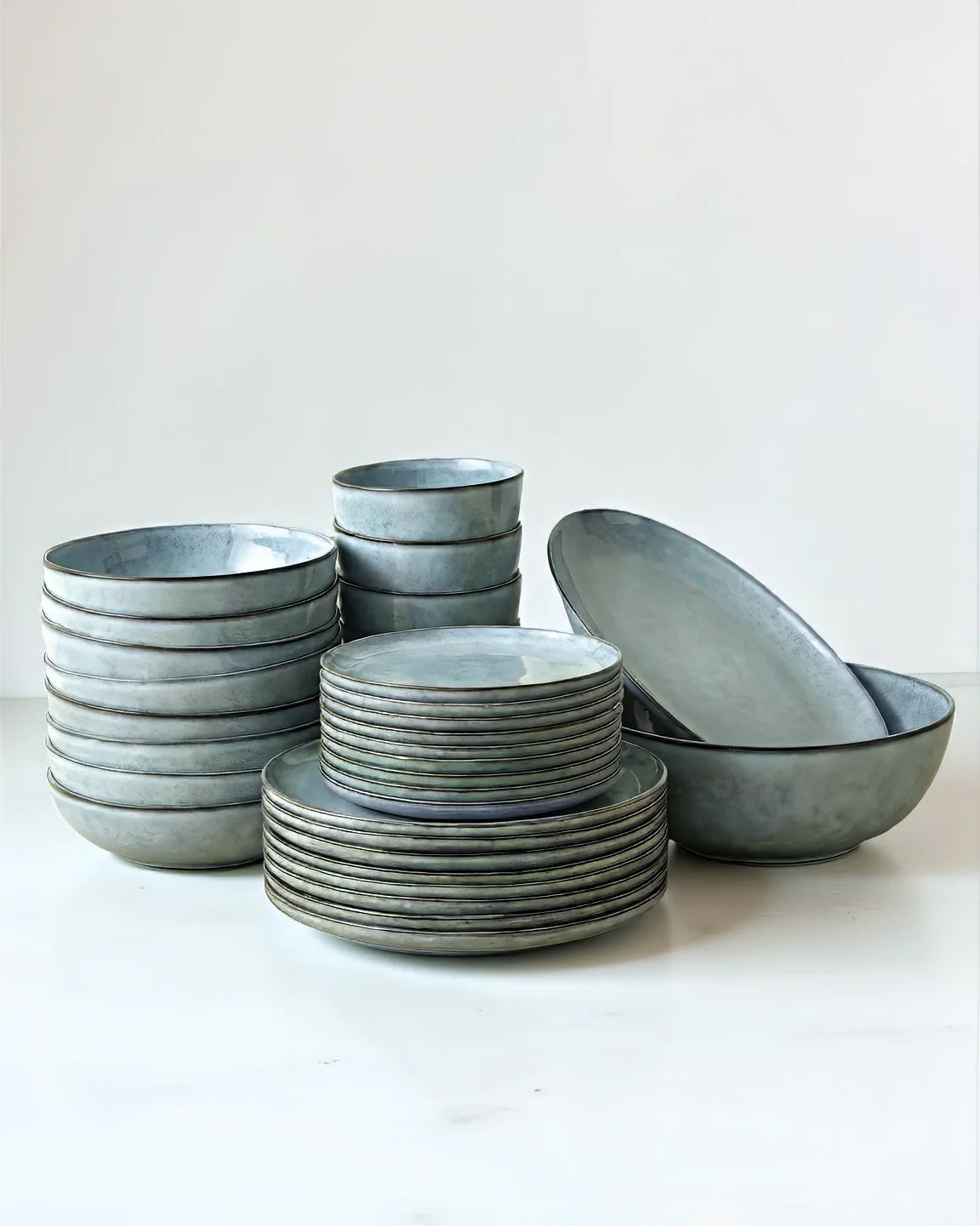 Nordic Fjord 32 piece dishware set with many plates and bowls stacked on a white backdrop