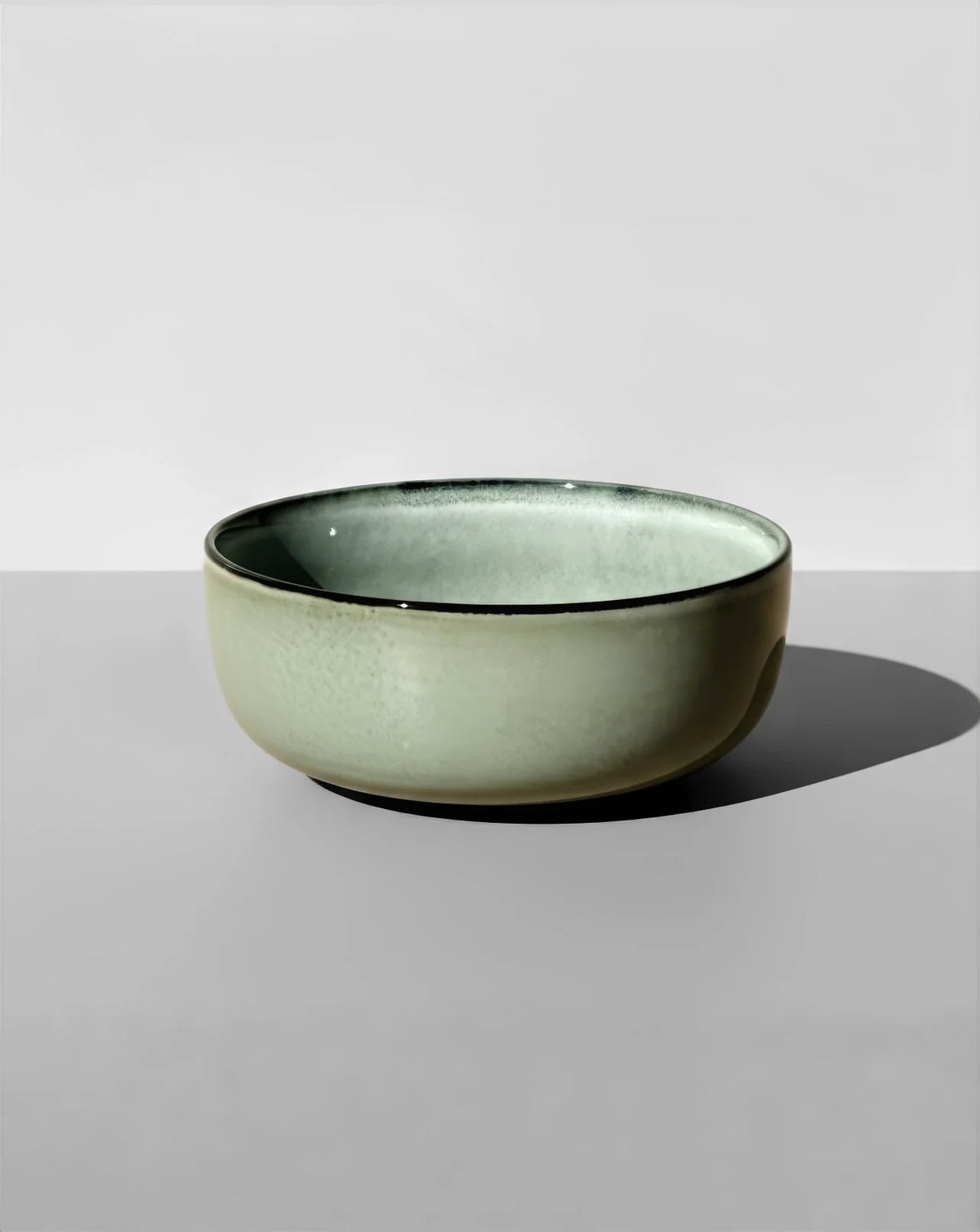 Side angle of a green Nordic Forest bowl with a dark rim and glossy glaze