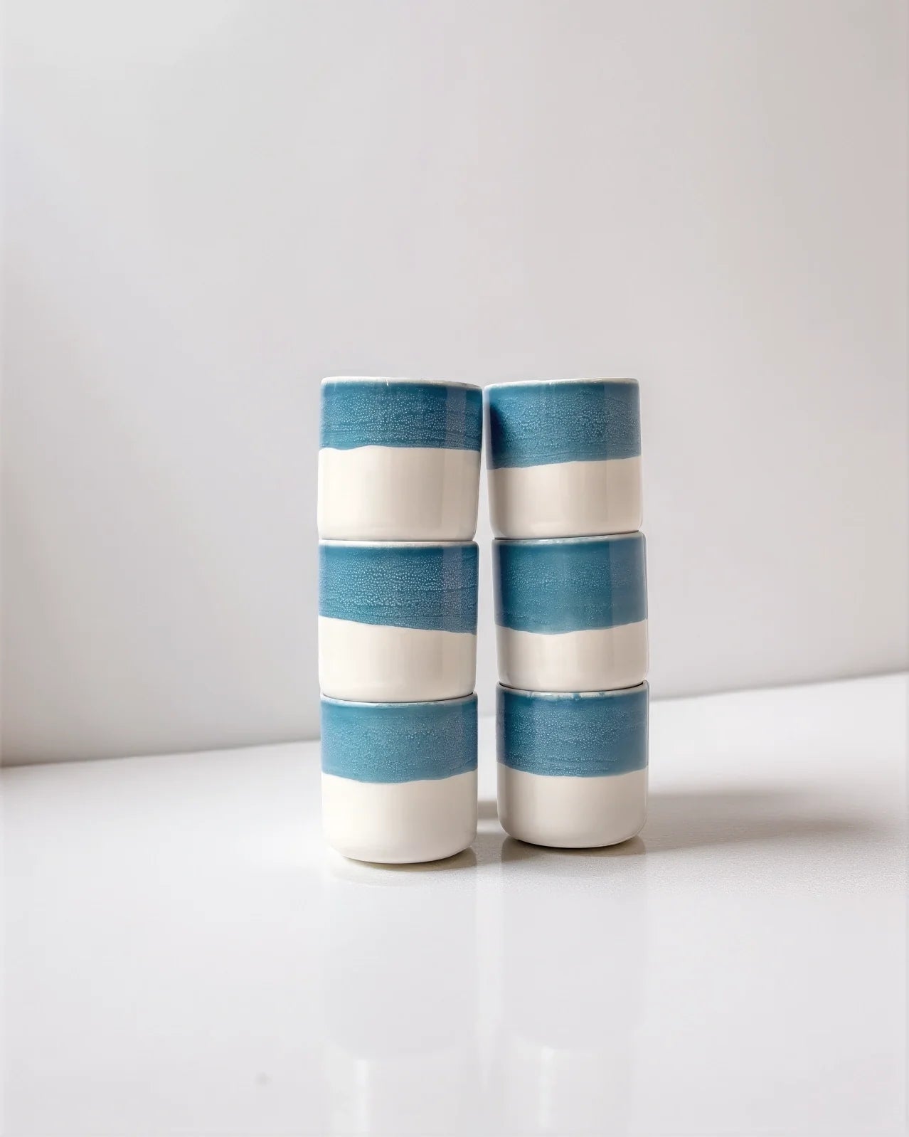 Six blue and white ceramic cups from the Vika Kaffeemomente set stacked in two columns.