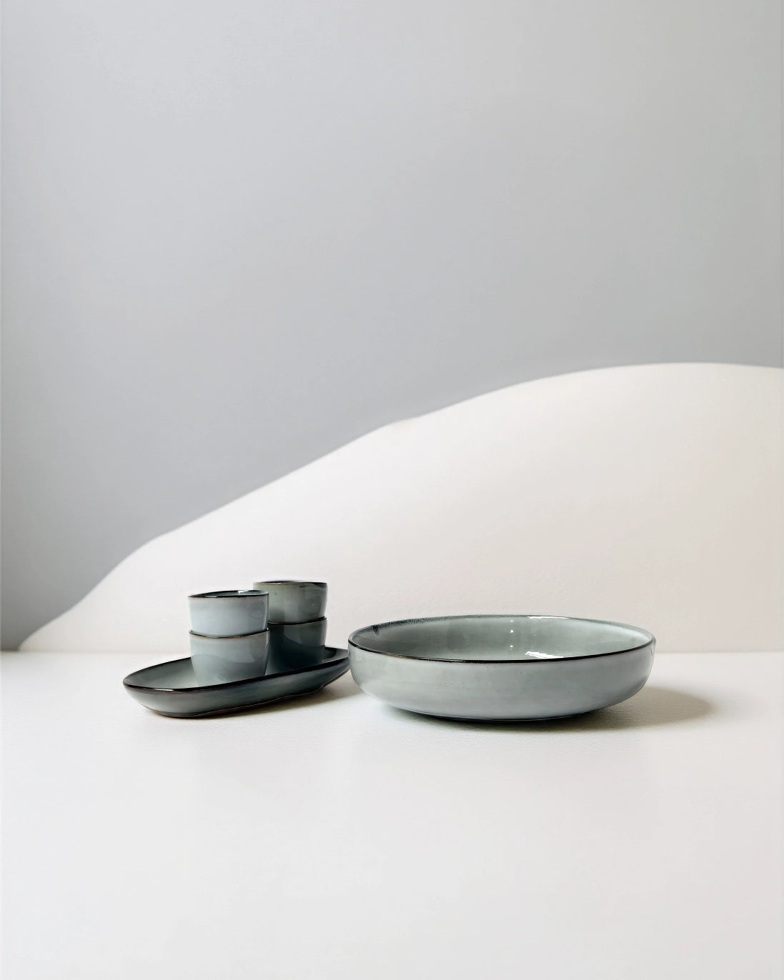 Nordic Forest Scandic Soul salad bowl with matching small cups on a dark tray.