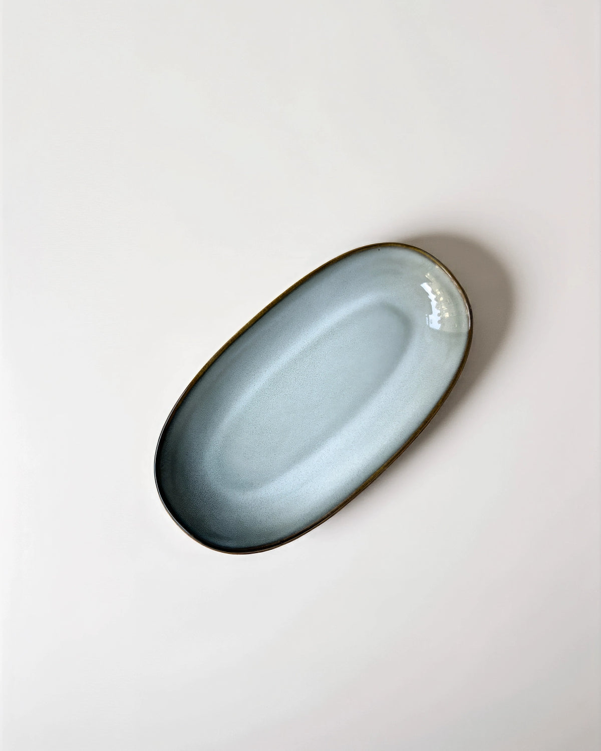 Nordic Forest oval serving plate in pale blue glaze with a dark rim