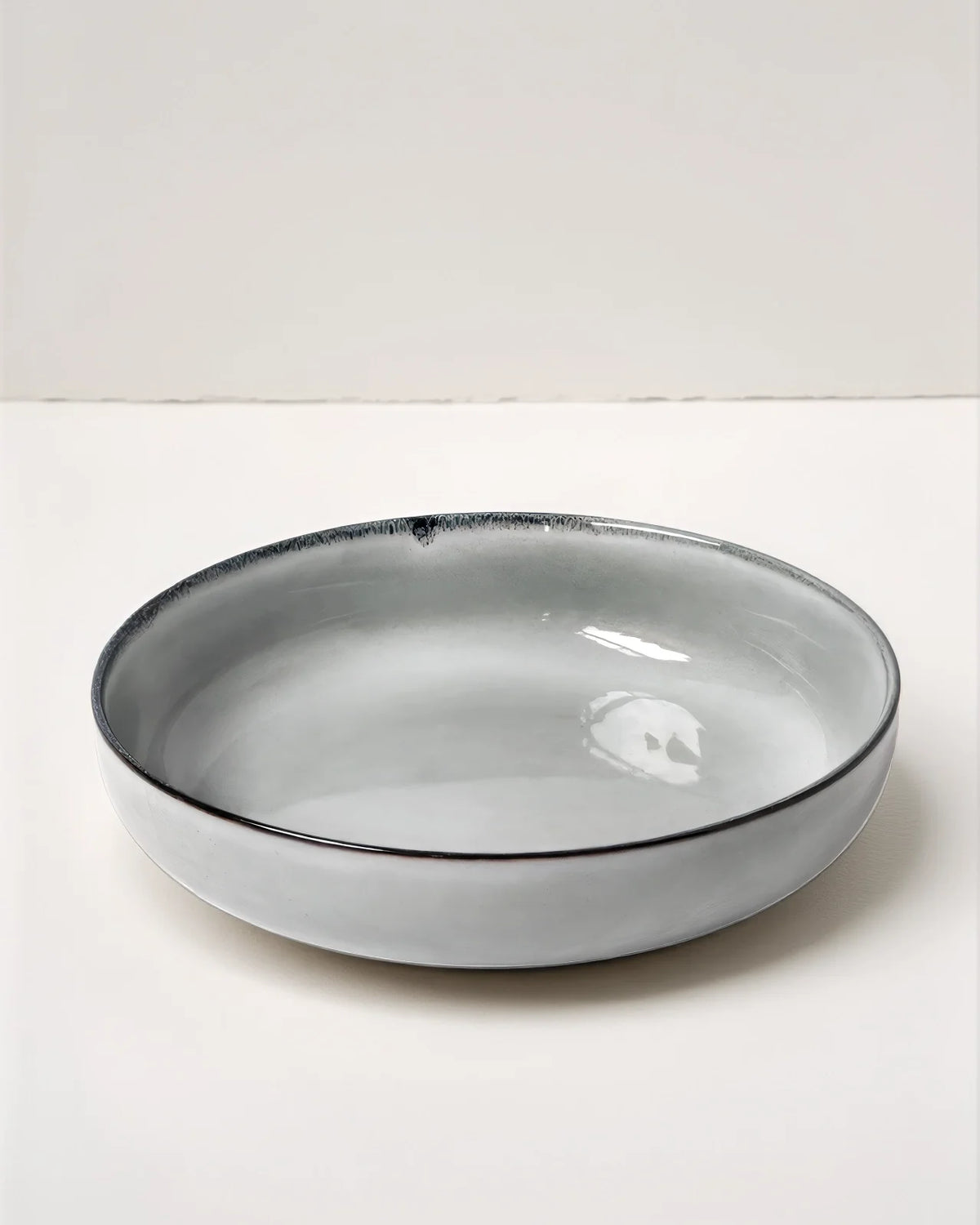 Shallow gray glazed bowl from Scandic Soul Nordic Forest 48 piece dinnerware set with a dark rim