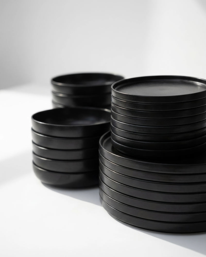 Stacked matte black tableware from Vela Luna 40 piece dish set